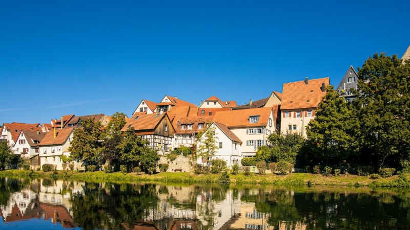 Besigheim: Picturesque half-timbered houses are reflected in the calm river under a clear blue sky., © Stuttgart-Marketing GmbH, Sarah Schmid Besigheim: Picturesque half-timbered houses are reflected in the calm river under a clear blue sky., © Stuttgart-Marketing GmbH, Sarah Schmid