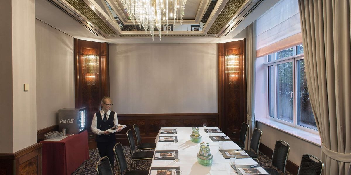Elegant meeting room with chandelier, table setting and service. Window with curtains, drinks and documents on the table., © Maritim Hotelgesellschaft mbH Elegant meeting room with chandelier, table setting and service. Window with curtains, drinks and documents on the table., © Maritim Hotelgesellschaft mbH