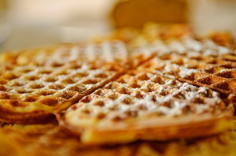 Frisch gebackene belgische Waffeln, mit Puderzucker bestreut, liegen einladend auf einem Teller., &copy; Literaturhaus Stuttgart