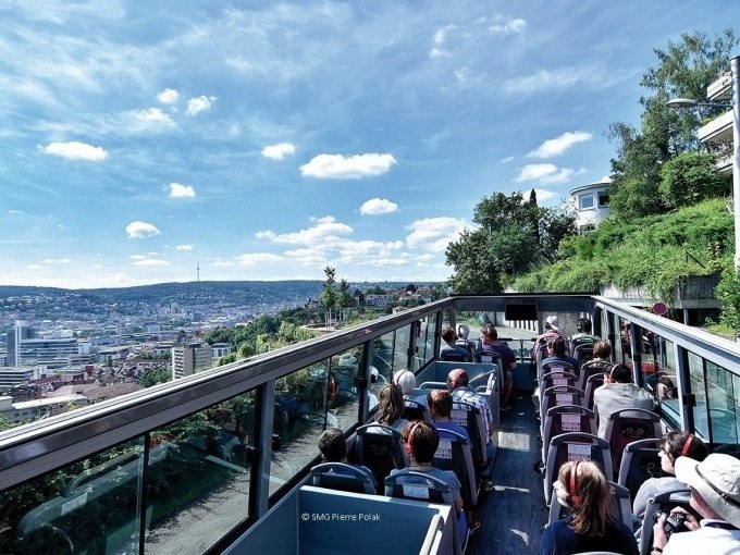 Touristen sitzen in einem offenen Doppeldeckerbus und genießen die Aussicht auf Stuttgart bei klarem Himmel., © SMG, Pierre Polak Touristen sitzen in einem offenen Doppeldeckerbus und genießen die Aussicht auf Stuttgart bei klarem Himmel., © SMG, Pierre Polak