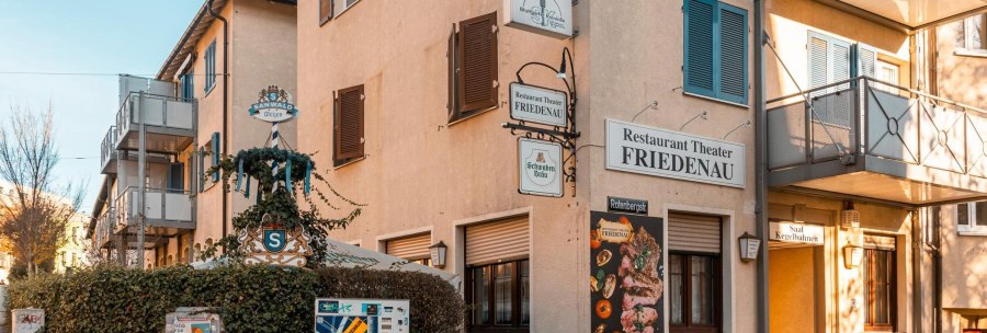 Das Restaurant Theater Friedenau zeigt seine Fassade mit mehreren Schildern und einem Werbeplakat. Ein Biergarten ist ebenfalls sichtbar., © Stuttgart-Marketing GmbH, Sarah Schmid Das Restaurant Theater Friedenau zeigt seine Fassade mit mehreren Schildern und einem Werbeplakat. Ein Biergarten ist ebenfalls sichtbar., © Stuttgart-Marketing GmbH, Sarah Schmid