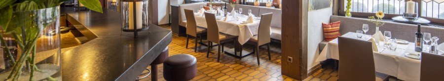 A cozy restaurant with a wooden beamed ceiling, set tables and large windows. Flowers and candles create an inviting atmosphere., © Hotel Gloria GmbH