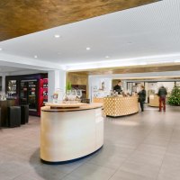 Moderne Vinothek mit eleganter Einrichtung, Weinregalen und einer zentralen Theke. Ein Weihnachtsbaum steht im Hintergrund., © Weinmanufaktur Stuttgart