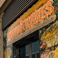 Gebäudefassade mit dem Schild 'Banh Mi & Bubbles' und buntem Wandgemälde mit asiatischen Motiven., © Stuttgart-Marketing GmbH, Sarah Schmid