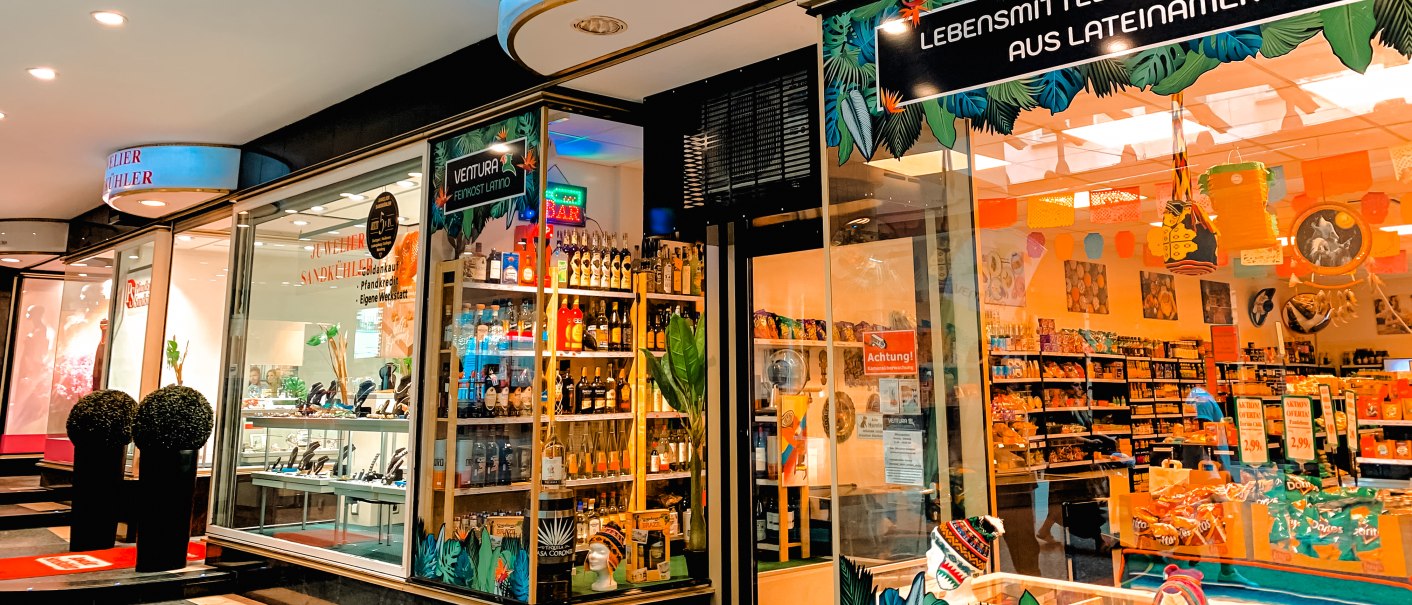 Ein Feinkostladen namens Ventura bietet lateinamerikanische Lebensmittel und Kunsthandwerk an. Das Schaufenster ist bunt dekoriert., © Feinkost Latino Ventura Ein Feinkostladen namens Ventura bietet lateinamerikanische Lebensmittel und Kunsthandwerk an. Das Schaufenster ist bunt dekoriert., © Feinkost Latino Ventura