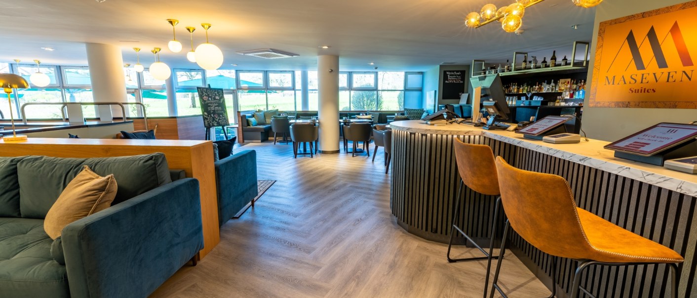 Moderne Hotellobby mit stilvoller Rezeption, gemütlichen Sitzbereichen und einer Bar. Helle Beleuchtung und große Fenster sorgen für eine einladende Atmosphäre., © MASEVEN Stuttgart SI-Centrum