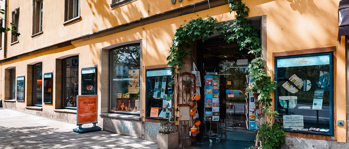 Exterior view of the Planie world store with a yellow fa&ccedil;ade, large windows and an entrance decorated with plants., &copy; Michael Latz