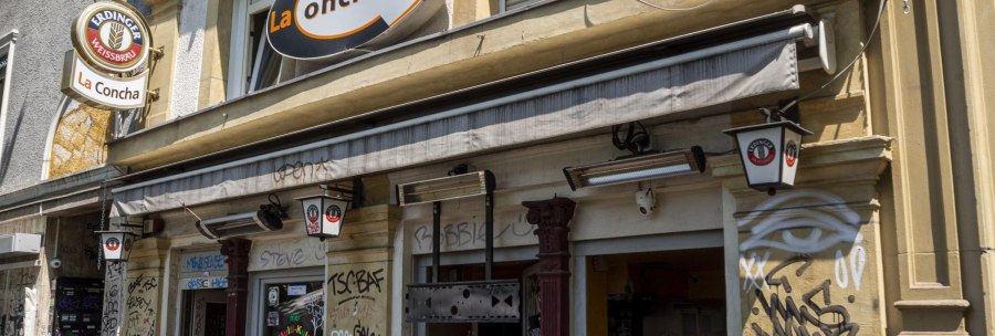 Fassade einer Bar namens La Concha mit Graffiti und Schildern von Erdinger Wei&szlig;br&auml;u. Die Au&szlig;enw&auml;nde sind mit Graffiti verziert., &copy; SMG, Sarah Schmid