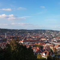 Panoramablick auf eine Stadt mit roten Dächern, umgeben von grünen Hügeln und blauem Himmel., © SMG Panoramablick auf eine Stadt mit roten Dächern, umgeben von grünen Hügeln und blauem Himmel., © SMG