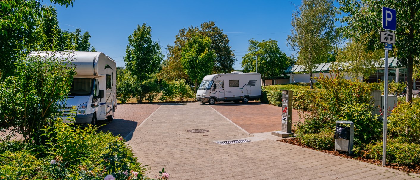 Wohnmobilstellplatz mit zwei Wohnmobilen, umgeben von Bäumen und Pflanzen, bei sonnigem Wetter., © Stuttgart-Marketing GmbH, Thomas Niedermüller
