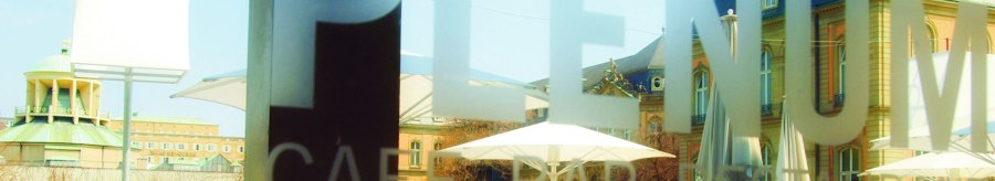 People sit under parasols in the outdoor area of a caf&eacute;. Historical buildings can be seen in the background., &copy; SMG