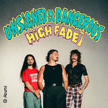 Drei Männer posieren vor einem bunten Schriftzug 'Unsigned & Dangerous High Fade'. Sie tragen lässige Kleidung und schauen in verschiedene Richtungen., © links im Bild Drei Männer posieren vor einem bunten Schriftzug 'Unsigned & Dangerous High Fade'. Sie tragen lässige Kleidung und schauen in verschiedene Richtungen., © links im Bild