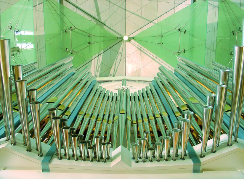 Modern organ with shiny metal pipes and green glass panels in the background. The architecture looks futuristic and elegant., &copy; Stiftsmusik Stuttgart