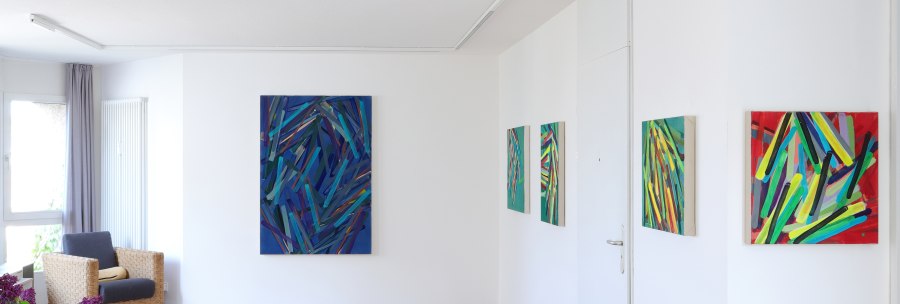 Galerie mit abstrakten Gemälden an weißen Wänden, Holzboden, Sessel und lila Blumen in einer Vase., © Galerie Klaus Braun Galerie mit abstrakten Gemälden an weißen Wänden, Holzboden, Sessel und lila Blumen in einer Vase., © Galerie Klaus Braun