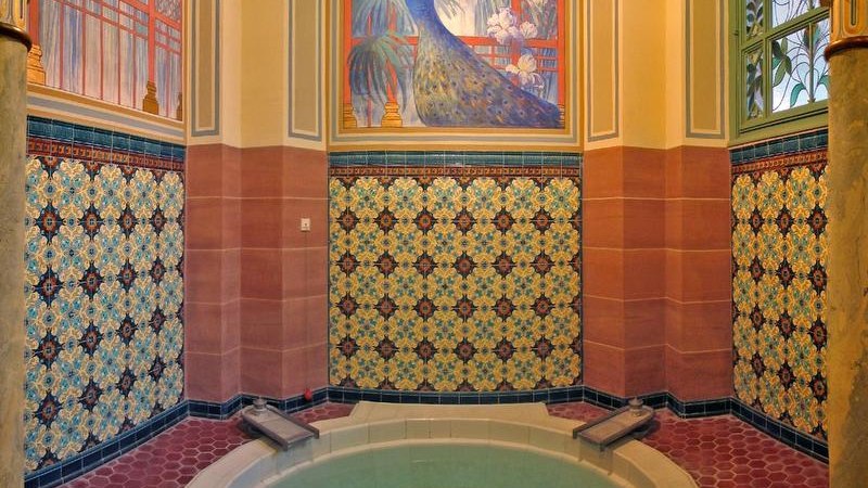 Thermalbad mit kunstvollen Mosaikfliesen und Wandmalerei eines Pfaus. Elegante, historische Gestaltung mit warmen Farben und dekorativen Elementen., © Mokni's Palais Hotel & Spa Thermalbad mit kunstvollen Mosaikfliesen und Wandmalerei eines Pfaus. Elegante, historische Gestaltung mit warmen Farben und dekorativen Elementen., © Mokni's Palais Hotel & Spa