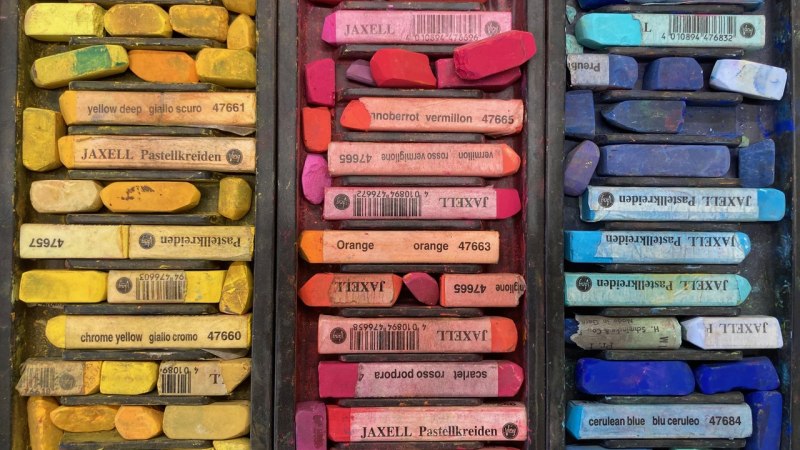 Drei F&auml;cher mit Pastellkreiden in Gelb-, Rot- und Blaut&ouml;nen, ordentlich sortiert. Jede Farbe ist mit einem Etikett versehen., &copy; Adolf H&ouml;lzel Stiftung
