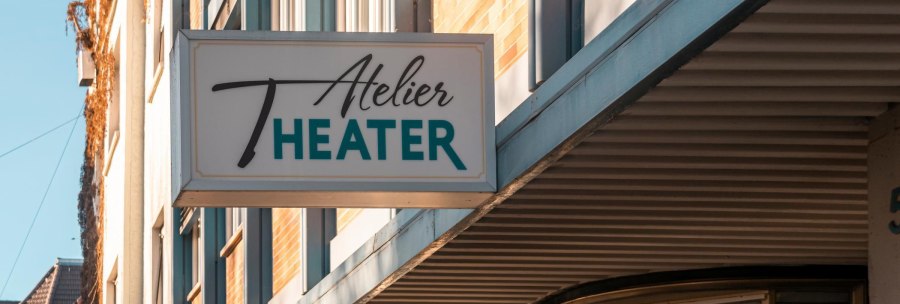 A sign with the words 'Atelier Theater' hangs on a building. The façade is modern and the weather is sunny., © SMG Stuttgart Marketing GmbH - Sarah Schmid A sign with the words 'Atelier Theater' hangs on a building. The façade is modern and the weather is sunny., © SMG Stuttgart Marketing GmbH - Sarah Schmid