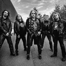 Five men in leather jackets stand confidently on a street. They are wearing rocker outfits and look seriously into the camera. Black and white photography., &copy; see on the left
