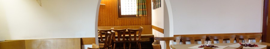 A cozy restaurant with wooden tables and chairs, decorated with pictures and flowers. An arch leads into another room., © Besenwirtschaft Familie Nerz A cozy restaurant with wooden tables and chairs, decorated with pictures and flowers. An arch leads into another room., © Besenwirtschaft Familie Nerz