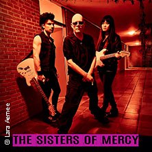 Drei Personen in schwarzer Kleidung posieren mit Gitarren in einem Flur. Der Schriftzug 'The Sisters of Mercy' ist unten zu sehen., © links im Bild Drei Personen in schwarzer Kleidung posieren mit Gitarren in einem Flur. Der Schriftzug 'The Sisters of Mercy' ist unten zu sehen., © links im Bild