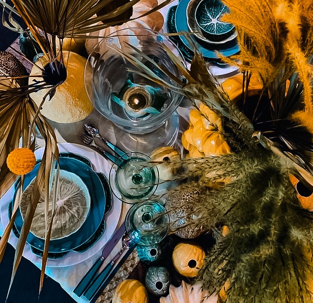 Ein stilvoll gedeckter Tisch mit blauen Tellern, Gläsern und gelben Trockenblumen. Kürbisse und Kerzen ergänzen die herbstliche Dekoration., © Merz & Benzing GmbH Ein stilvoll gedeckter Tisch mit blauen Tellern, Gläsern und gelben Trockenblumen. Kürbisse und Kerzen ergänzen die herbstliche Dekoration., © Merz & Benzing GmbH