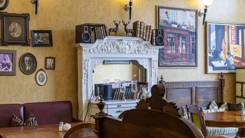 A cozy caf&eacute; with antique furniture, framed pictures and decorative elements on the walls., &copy; SMG, Sarah Schmid