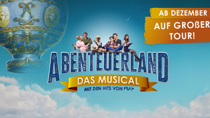 Werbung für das Musical 'Abenteuerland' mit einer Heißluftballon-Grafik und einer Gruppe von Menschen. Text: 'Ab Dezember auf großer Tour!', © links im Bild Werbung für das Musical 'Abenteuerland' mit einer Heißluftballon-Grafik und einer Gruppe von Menschen. Text: 'Ab Dezember auf großer Tour!', © links im Bild
