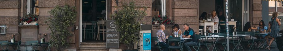 Caf&eacute; mit gelbem Vordach an einer Stra&szlig;enecke. G&auml;ste sitzen drau&szlig;en an Tischen. Schild mit 'Lumen' und Stra&szlig;enschild 'Schwabstr.' sichtbar., &copy; SMG, Sarah Schmid