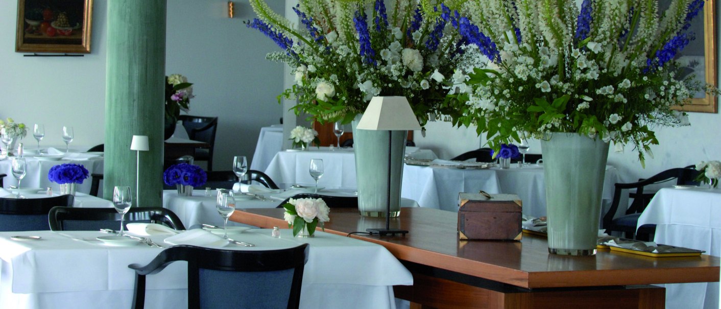 Elegantes Restaurant mit weißen Tischdecken, großen Blumenarrangements und stilvoller Dekoration. Die Atmosphäre wirkt gehoben und einladend., © Vincent Klinik Elegantes Restaurant mit weißen Tischdecken, großen Blumenarrangements und stilvoller Dekoration. Die Atmosphäre wirkt gehoben und einladend., © Vincent Klinik