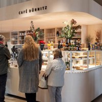 Bar with beverages, cakes and other snacks. Three people are waiting in line., &copy; SMG, Sarah Schmid