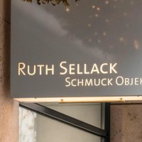 Ein Leuchtschild mit der Aufschrift 'Ruth Sellack Schmuck Objekte' h&auml;ngt an einer Geb&auml;udewand aus Stein., &copy; SMG, Sarah Schmid