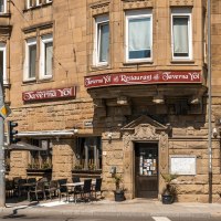 Historic building with restaurant Taverna Yol, outdoor seating, street signs and traffic lights. Sunny day, flowers in windows., &copy; SMG Stuttgart Marketing GmbH - Sarah Schmid