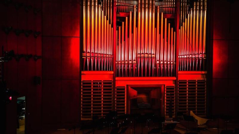 An impressive organ in a concert hall, dramatically illuminated with red light. The pipes stretch up to the ceiling., © Staatliche Hochschule für Musik und Darstellende Kunst An impressive organ in a concert hall, dramatically illuminated with red light. The pipes stretch up to the ceiling., © Staatliche Hochschule für Musik und Darstellende Kunst