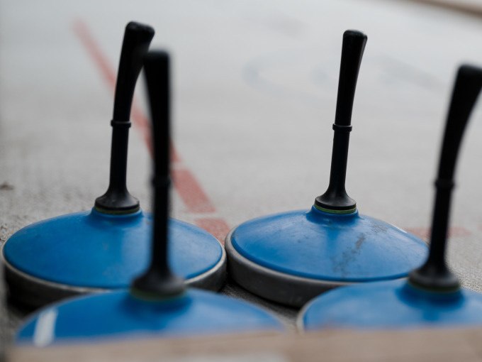 Four blue curling sticks stand on an ice rink, ready for curling., &copy; Cool-Tours StattReisen