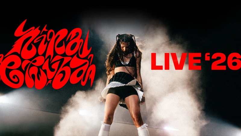 Eine Frau performt auf der Bühne, umgeben von Nebel. Der Schriftzug 'LIVE '26' ist in Rot hervorgehoben., © links im Bild Eine Frau performt auf der Bühne, umgeben von Nebel. Der Schriftzug 'LIVE '26' ist in Rot hervorgehoben., © links im Bild