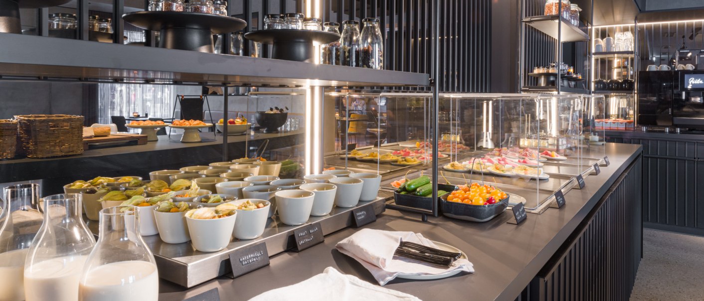 Ein modernes Frühstücksbuffet mit einer Auswahl an Speisen, Getränken und Geschirr in einem stilvollen Restaurant., © EmiLu Hotel GmbH