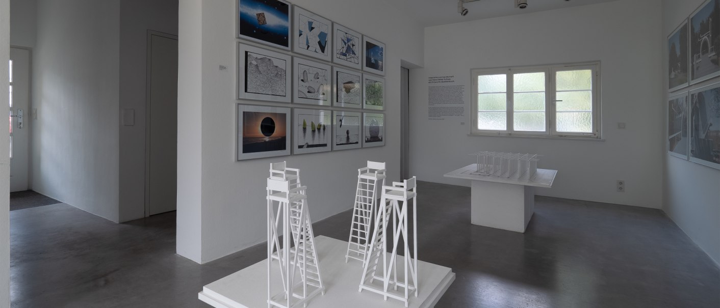 Heller Ausstellungsraum der Architekturgalerie mit gerahmten Arbeiten, Texttafel und wei&szlig;en Architekturmodellen auf Podesten., &copy; Thomas F&uuml;tterer