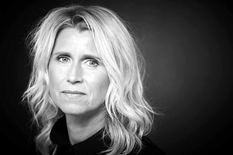 Schwarz-weiß Porträt einer Frau mit blonden, welligen Haaren und ernstem Gesichtsausdruck vor dunklem Hintergrund., © Börsenverein des Deutschen Buchhandels, Landesverband Baden-Württemberg e.V. Schwarz-weiß Porträt einer Frau mit blonden, welligen Haaren und ernstem Gesichtsausdruck vor dunklem Hintergrund., © Börsenverein des Deutschen Buchhandels, Landesverband Baden-Württemberg e.V.