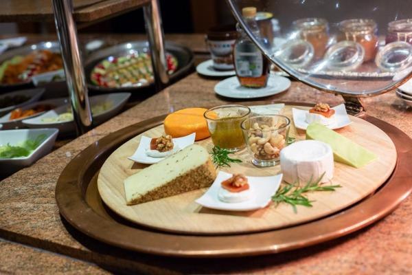 Verschiedene Käsesorten, Nüsse und Marmelade auf einem Holzteller, Teil eines Frühstücksbuffets., © Kronen Hotel GmbH Verschiedene Käsesorten, Nüsse und Marmelade auf einem Holzteller, Teil eines Frühstücksbuffets., © Kronen Hotel GmbH