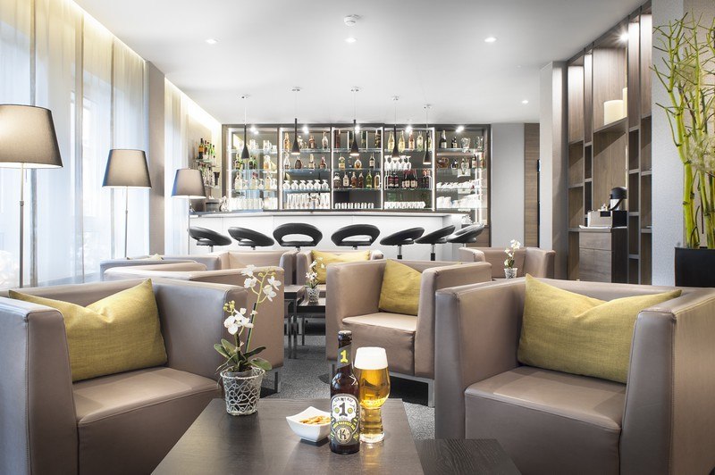 Modern bar/lobby with comfortable armchairs, bar stools, and a well-stocked bar. Inviting atmosphere with drinks and snacks on the tables., &copy; TOMAS