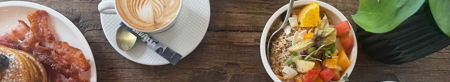 A richly laid breakfast table with coffee, pancakes with bacon, avocado with scrambled eggs and a bowl of fresh fruit., &copy; SMG