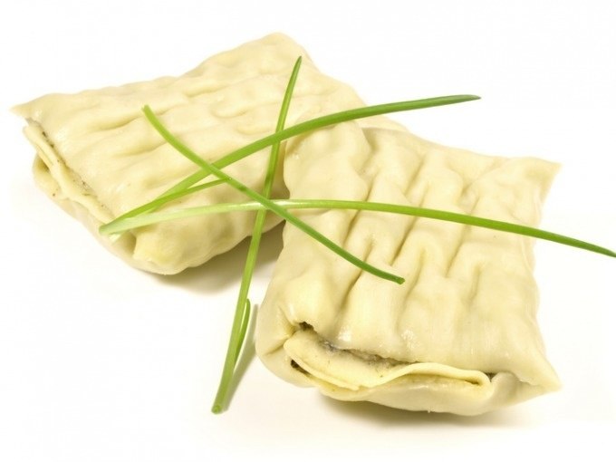 Zwei Maultaschen liegen auf einem wei&szlig;en Hintergrund, garniert mit frischem Schnittlauch., &copy; Cool-Tours StattReisen