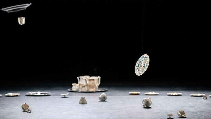 Porzellanobjekte schweben und liegen auf einer dunklen Bühne, darunter Tassen und Teller., © FITZ Das Theater animierter Formen