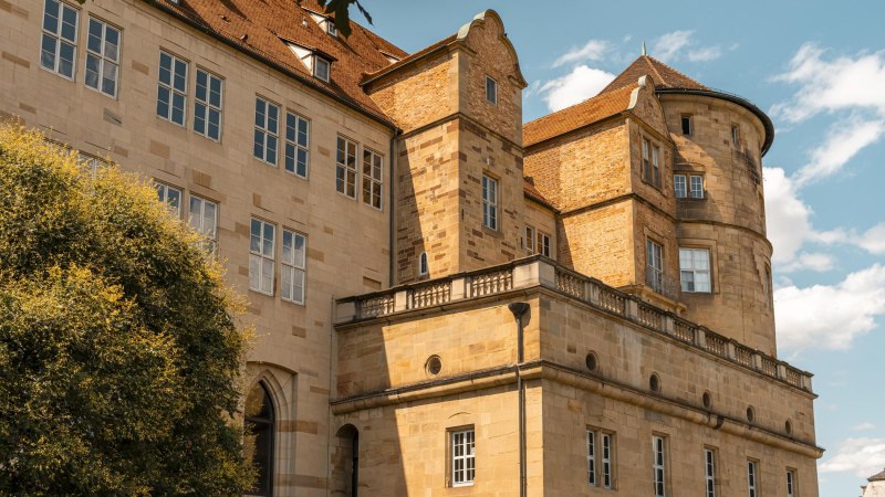 Ein altes Schloss mit markanten Türmen und vielen Fenstern, umgeben von einem blauen Himmel und einigen Wolken., © Stuttgart-Marketing GmbH, Sarah Schmid Ein altes Schloss mit markanten Türmen und vielen Fenstern, umgeben von einem blauen Himmel und einigen Wolken., © Stuttgart-Marketing GmbH, Sarah Schmid