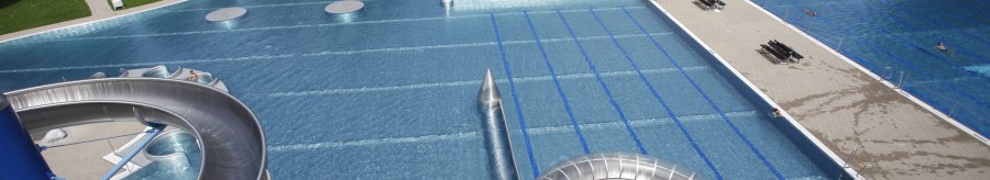 Freibad Rosental mit gro&szlig;er Wasserrutsche, mehreren Schwimmbecken und umliegenden Gr&uuml;nfl&auml;chen. Menschen entspannen auf der Wiese., &copy; Stuttgarter B&auml;der