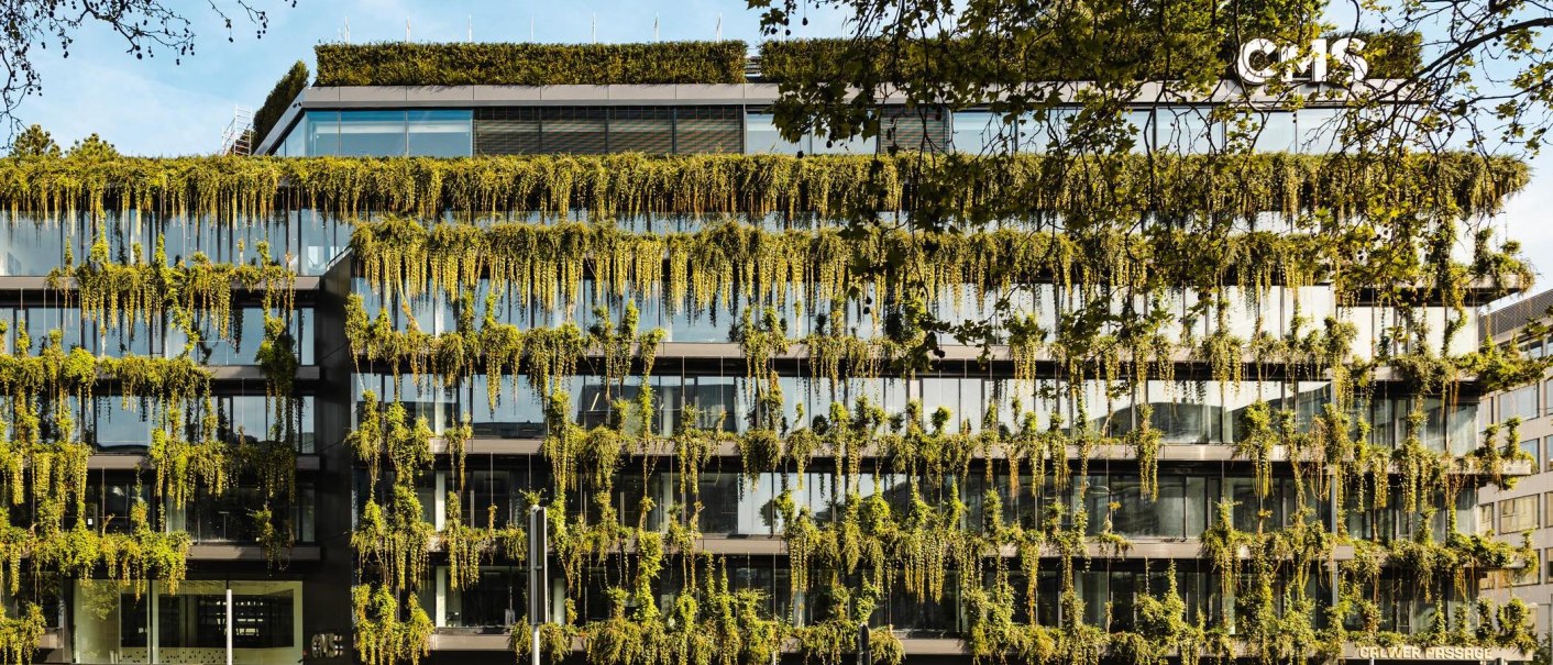 Ein modernes Geb&auml;ude mit einer &uuml;ppig begr&uuml;nten Fassade und gro&szlig;en Glasfenstern. Pflanzen h&auml;ngen von den Etagen herab., &copy; Stuttgart-Marketing GmbH, Sarah Schmid