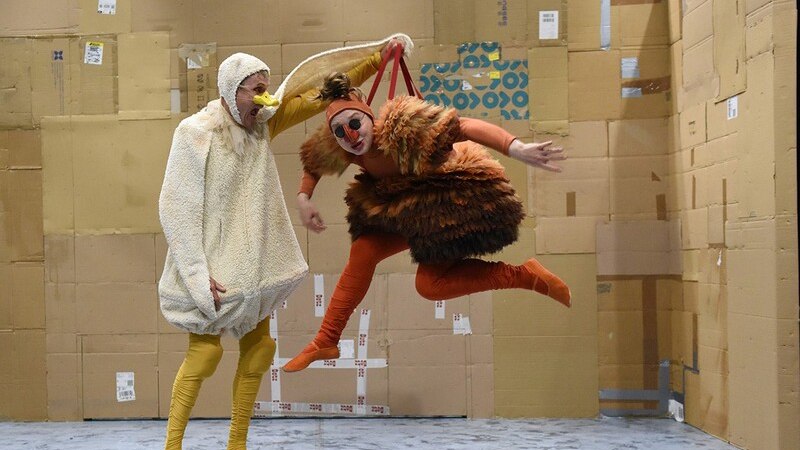 Two people in animal costumes, one as a duck and one as a chicken, act in a room with cardboard walls. Humorous scene., &copy; Theaterhaus Stuttgart e.V.