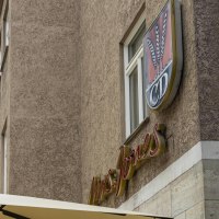 A building with the lettering 'Mrs Jones' and a logo with ears of corn and the letters 'CD'. A parasol is visible in the foreground., © SMG, Sarah Schmid A building with the lettering 'Mrs Jones' and a logo with ears of corn and the letters 'CD'. A parasol is visible in the foreground., © SMG, Sarah Schmid