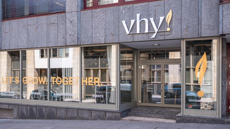 Eingang eines Restaurants mit der Aufschrift 'vhy!' und großen Fenstern. Schriftzug 'LET'S GROW. TOGETHER.' auf den Fenstern., © SMG, Sarah Schmid Eingang eines Restaurants mit der Aufschrift 'vhy!' und großen Fenstern. Schriftzug 'LET'S GROW. TOGETHER.' auf den Fenstern., © SMG, Sarah Schmid