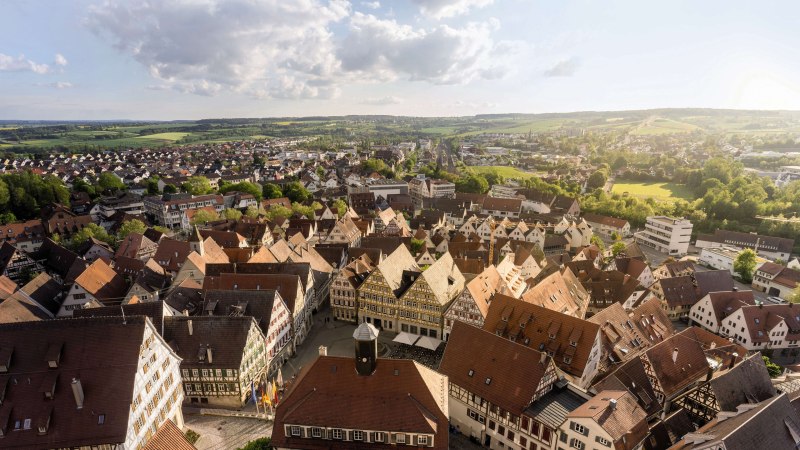 Panorama of a town with many half-timbered houses, surrounded by green countryside and fields under a cloudy sky., © Stuttgart-Marketing GmbH, Martina Denker Panorama of a town with many half-timbered houses, surrounded by green countryside and fields under a cloudy sky., © Stuttgart-Marketing GmbH, Martina Denker